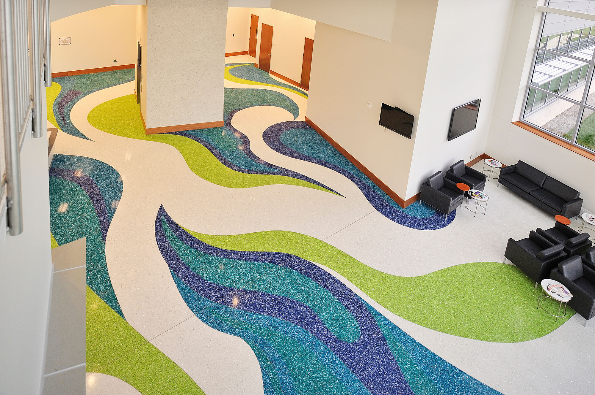 Custom commercial terrazzo installation with sweeping colored patterns in a public lobby